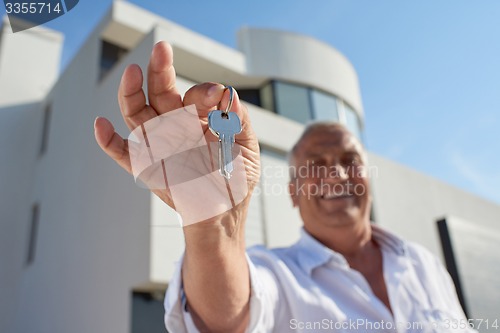 Image of senior man in front of modern home