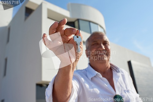 Image of senior man in front of modern home