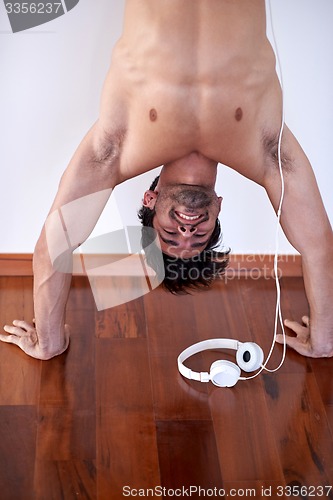 Image of handsome young man listening music on headphones