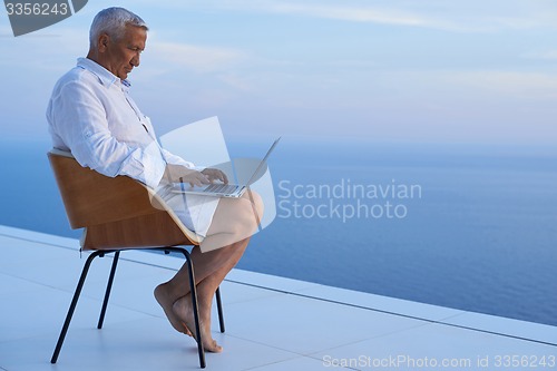 Image of senior man working on laptop computer