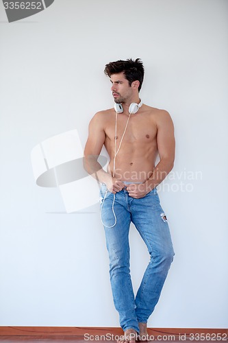 Image of handsome young man listening music on headphones