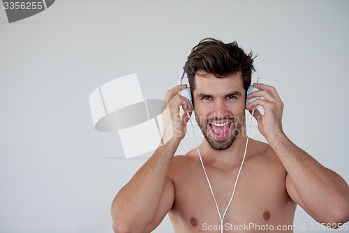 Image of handsome young man listening music on headphones