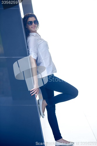 Image of relaxed woman in front of luxury modern home