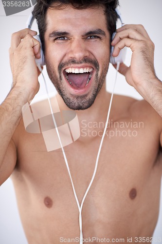 Image of handsome young man listening music on headphones