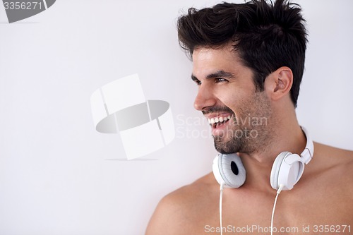 Image of handsome young man listening music on headphones