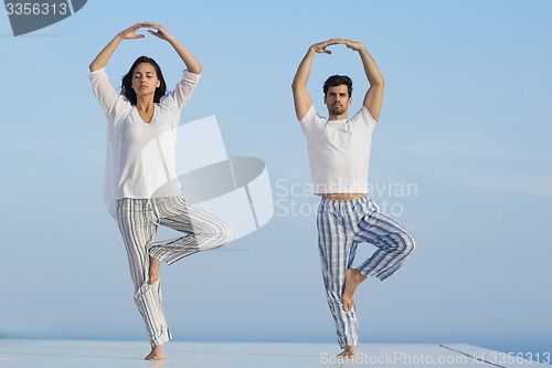 Image of young couple practicing yoga