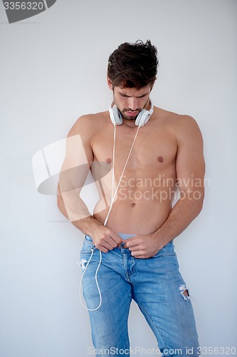 Image of handsome young man listening music on headphones