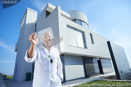 Image of senior man in front of modern home