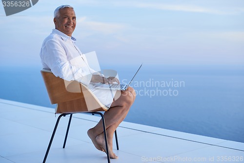 Image of senior man working on laptop computer