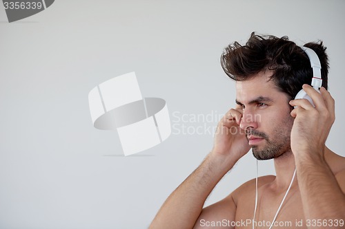 Image of handsome young man listening music on headphones