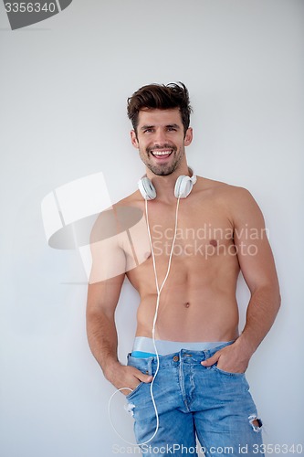 Image of handsome young man listening music on headphones