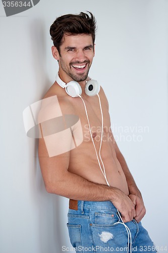 Image of handsome young man listening music on headphones