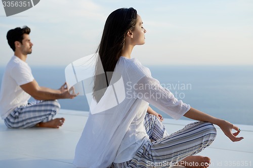 Image of young couple practicing yoga