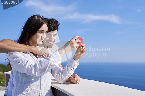 Image of young couple taking selfie with phone