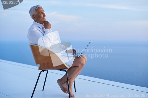 Image of senior man working on laptop computer