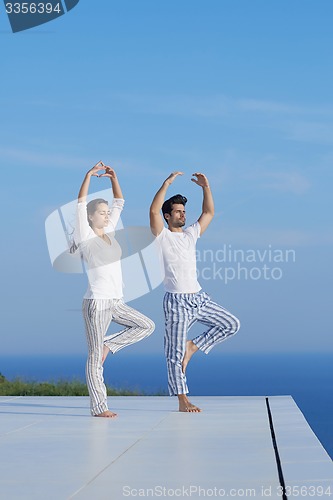 Image of young couple practicing yoga