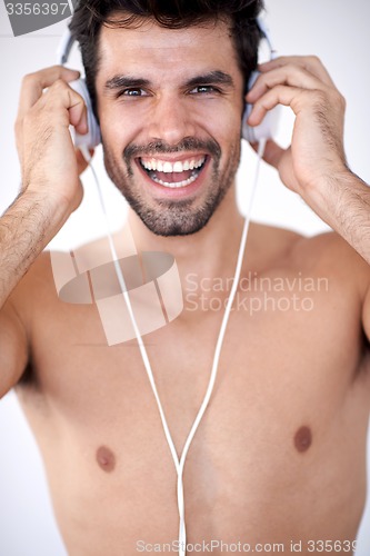 Image of handsome young man listening music on headphones