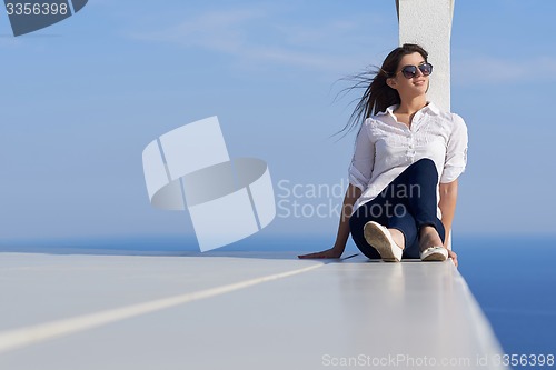 Image of relaxed woman in front of luxury modern home