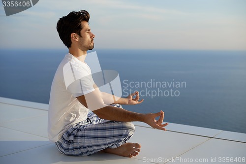 Image of young man practicing yoga