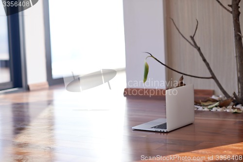 Image of modern home indoors with laptop on floor