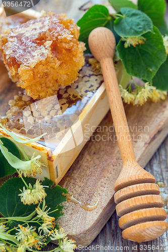 Image of Honey comb and a wooden spoon.