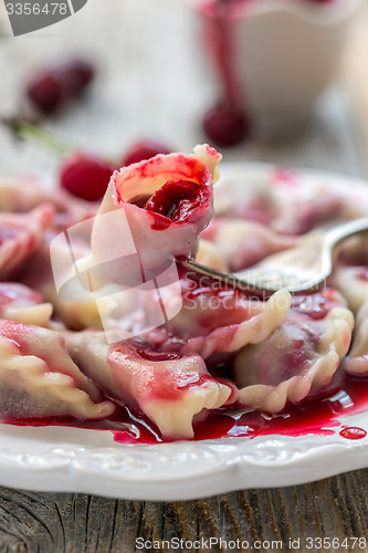 Image of Dumplings with a cherry on a fork.