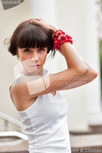 Image of Attractive sad girl with red beads