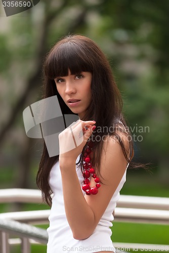 Image of Attractive sad girl with red beads