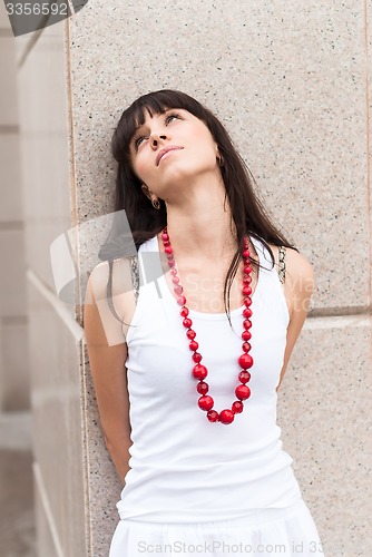 Image of Attractive sad girl with red beads