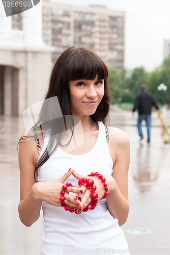 Image of Young pretty woman walking on city after rain