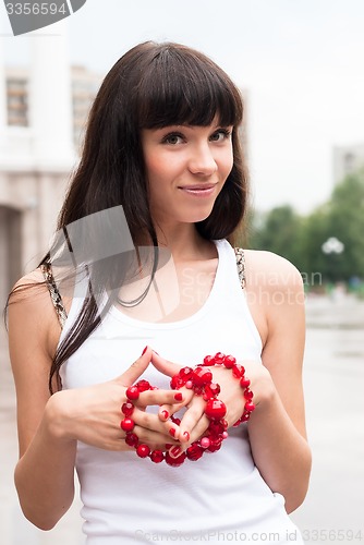 Image of Young pretty woman walking on city after rain