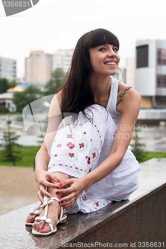 Image of Attractive smiling woman sits over city background