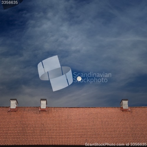 Image of tiled top of the roof, cloudy blue sky