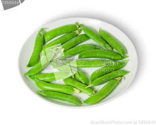 Image of Several pods of peas on a white plate