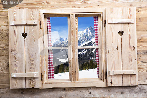 Image of Wooden window with snowy mountain reflections