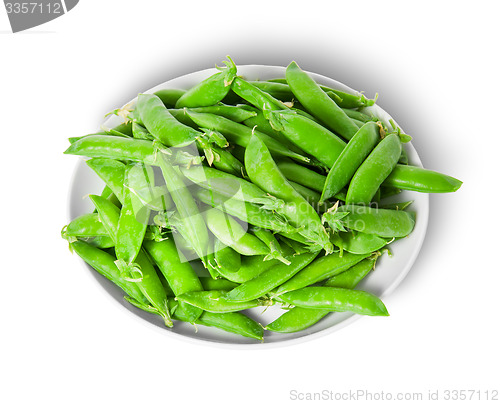 Image of Small pile of green peas in pods on white plate