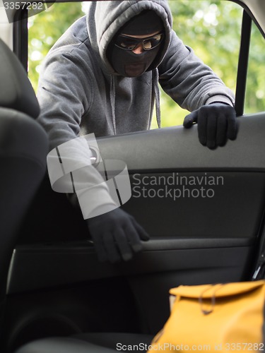 Image of Transportation crime concept .Thief stealing bag from the car