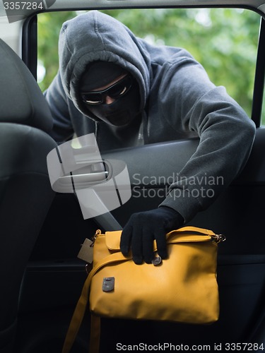 Image of Transportation crime concept .Thief stealing bag from the car