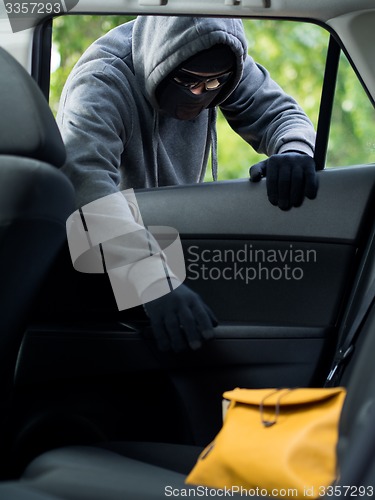 Image of Transportation crime concept .Thief stealing bag from the car