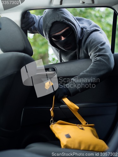 Image of Transportation crime concept .Thief stealing bag from the car