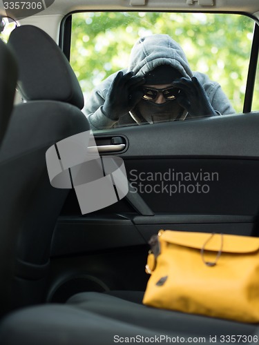 Image of Transportation crime concept .Thief stealing bag from the car