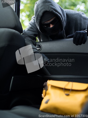 Image of Transportation crime concept .Thief stealing bag from the car