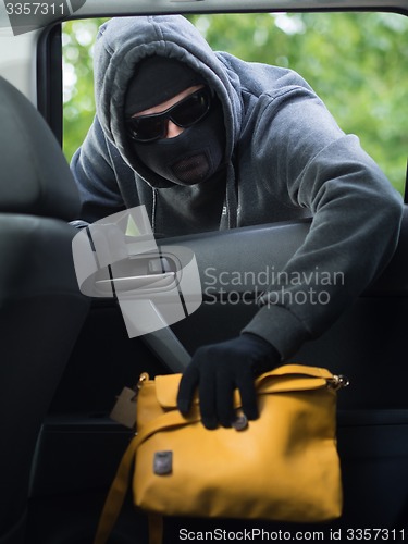 Image of Transportation crime concept .Thief stealing bag from the car