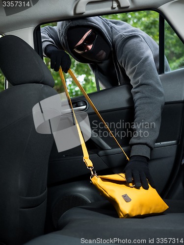 Image of Transportation crime concept .Thief stealing bag from the car