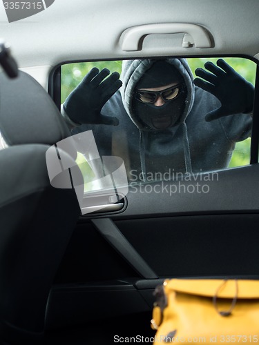 Image of Transportation crime concept .Thief stealing bag from the car