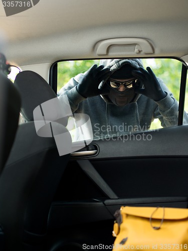 Image of Transportation crime concept .Thief stealing bag from the car