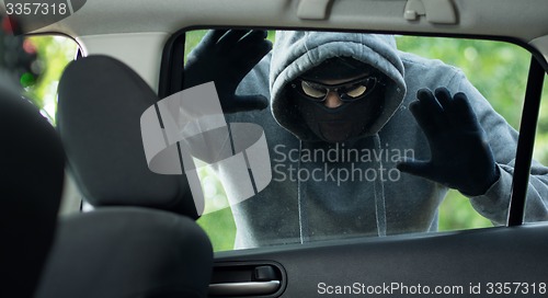 Image of Transportation crime concept .Thief stealing bag from the car