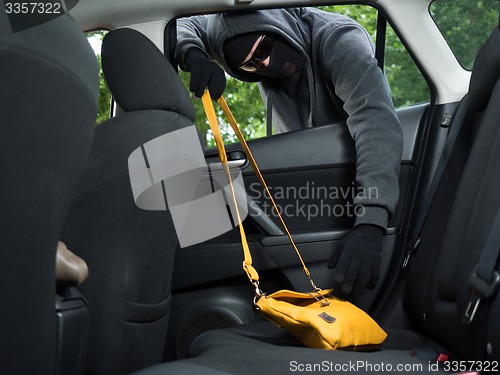 Image of Transportation crime concept .Thief stealing bag from the car