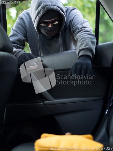 Image of Transportation crime concept .Thief stealing bag from the car