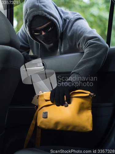 Image of Transportation crime concept .Thief stealing bag from the car